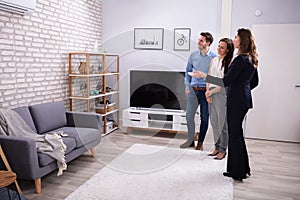 Realtor Showing Air Conditioner To Young Couple