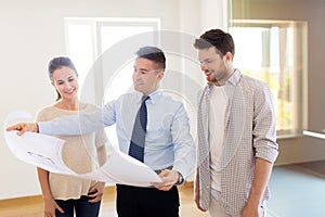 Realtor showing blueprint of new home to couple