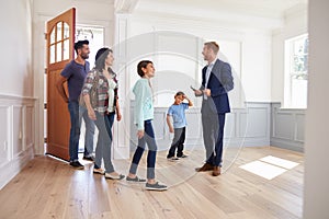 Realtor Showing Hispanic Family Around New Home photo