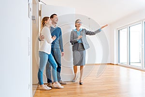 Realtor showing house to a young couple photo