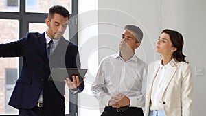 Realtor showing office to customers with tablet pc