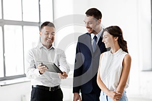 Realtor showing tablet pc to customers at office