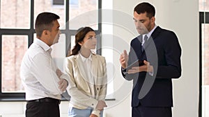 Realtor showing tablet pc to customers at office