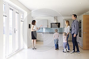 Realtor Showing Young Family Around Property For Sale photo