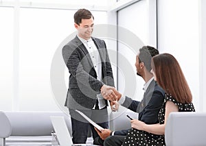 Realtor and the young couple shaking hands with each other