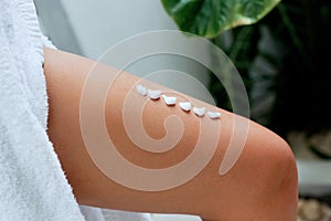 Ð¡ream on leg. Woman hand is applying moisturizing lotion on skin. Beauty and Body care. Closeup on female hand apply cream.   Pro