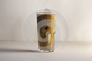 Ð¡ream is mixed with iced coffee after pouring