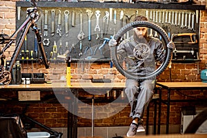 Reapairman with bicycle wheel in the workshop