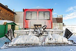 Rear back door window view covered with snow after blizzard snowfall of red modern snowcat ratrack grooming machine