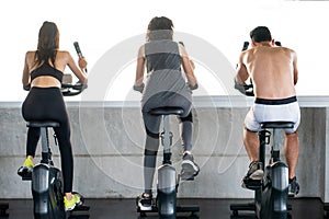 rear back view of Group of fitness people exercise with bikes together in gym . Cycling . workout . sport . training