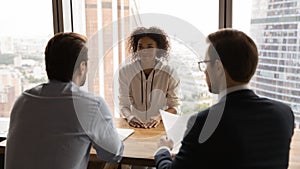 Rear back view HR male managers interviewing African female applicant