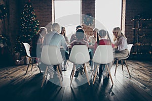 Rear back view of noel evening family gathering. Grey-haired grandparents, brother, sister, son, boy daughter at house