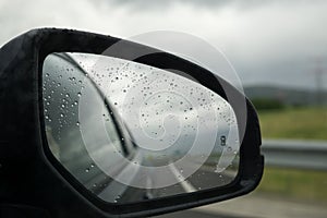 Rear car mirror with snow during rainy day. Slovakia