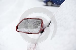 Rear car mirror with snow during winter. Slovakia