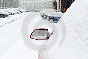 Rear car mirror with snow during winter. Slovakia