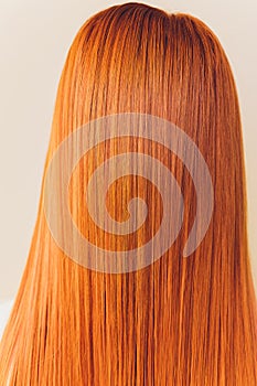 Rear closeup view of the shoulders of red haired carrot-top female.