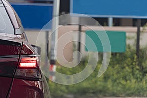 Rear corner of the luxury red car with brake lights.