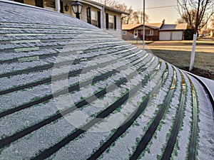 Rear defroster working on a car melting ice at sunrise