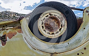 The rear driver side tire on an antique overturned truck