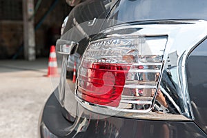 The rear end of a silver car with focus on the brake lights