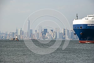 Rear of huge vessel in front of hazy Manhattan Skyline, New York City