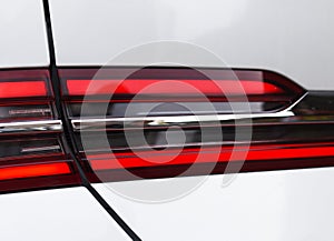 Rear LED headlamp of a modern car. Brake taillight. Red stop lighting of highway vehicles. Cars ambient lighting. Cars taillight