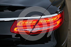 Rear light of red business car. Close up.