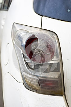 The rear light of a white car was damaged due to an accident with sunlight.