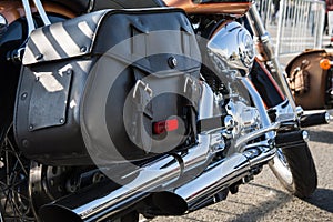 Rear part of the classic motorcycle with saddlebagsm made of black genuine leather and lots of chrome parts. Motorcycle is parked