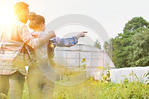 Rear photo of a loving husband and wife farmers looking loving over their beautiful farm