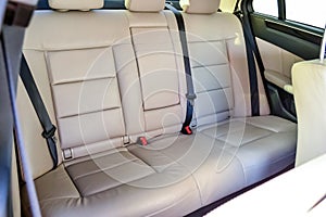 The rear seats of the car in the sedan body are white leather upholstered with the armrest folded down after dry cleaning and