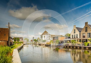 Rear side homes on waterfront the Drecht against blue sky with clouds