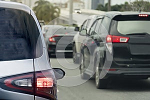 Rear side of silver car on the asphalt road turn on brake light and heading towards the goal of the trip.