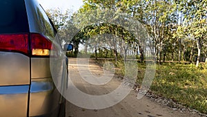 Rear side of traveling car on soil road with turn on turn light signal.