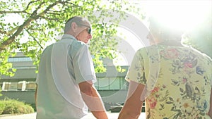 Rear view of an active senior caucasian tourist couple walking in london backlit by the sun