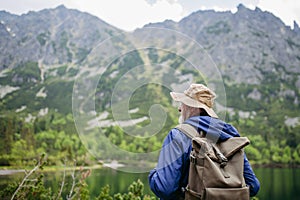 Zadný pohľad na aktívneho staršieho muža na turistike v jesenných horách.