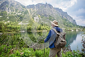 Zadní pohled na aktivní starší muž turistiku v podzimních horách.