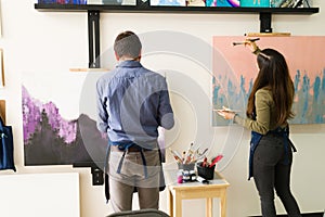 Rear view of an adult couple taking a painting class