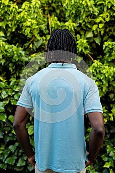 Rear view of african american man with dreadlocks wearing pale blue polo shirt in garden