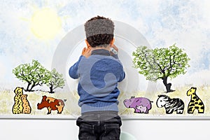 Rear view of afro american kid drawing animals on white board