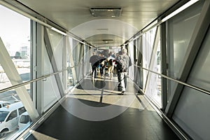 Rear view of an Airline Passengers in the airport bridge, Jet bridge where passengers connect with the plane. airport terminal.