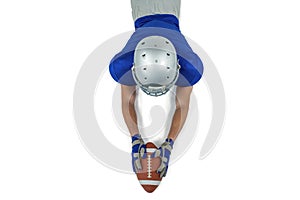 Rear view of American football player reaching towards ball