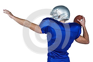 Rear view of American football player throwing ball