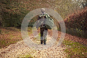 Rear View Of American Soldier In Uniform Carrying Kitbag Returning Home On Leave