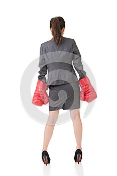 Rear view of Asian business woman with boxing gloves