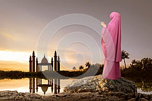 Rear view of asian muslim woman with headscarf praying