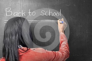 Rear view of asian student woman writing Back to School on the blackboard