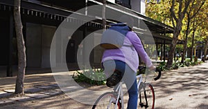 Rear view of asian woman riding bicycle on the road