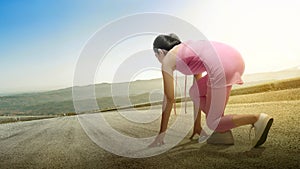 Rear view of an Asian woman in the start position ready to run