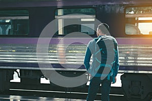 Rear view of asian young hipster man standing and waiting train